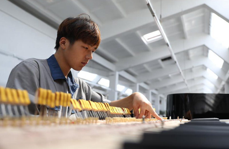 Arbeiter stellen Klaviere in Klavierfabrik in Nordostchina her