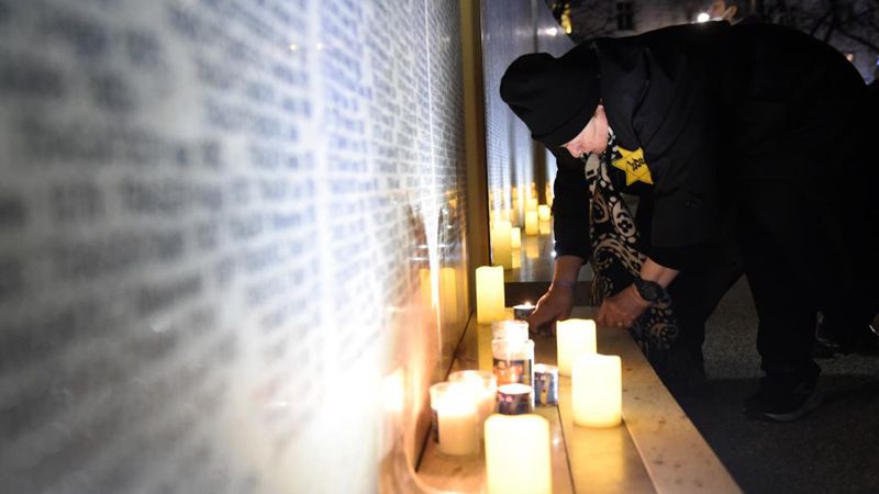 Menschen gedenken Opfer an Shoah-Gedenkmauer mit Namen in Wien