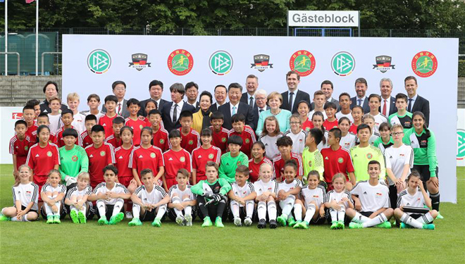 Xi und Merkel schauen sich ein Fußball-Freundschaftsspiel zwischen chinesischen und deutschen Jugendfußballmannschaften an