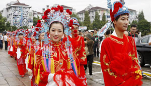 Neu Verheiratete nehmen an einer traditionellen Gruppenhochzeit in Shanghai teil