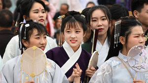 Frauen in traditionellen Kostümen nehmen an Parade im Wuhan Garden Expo Park teil